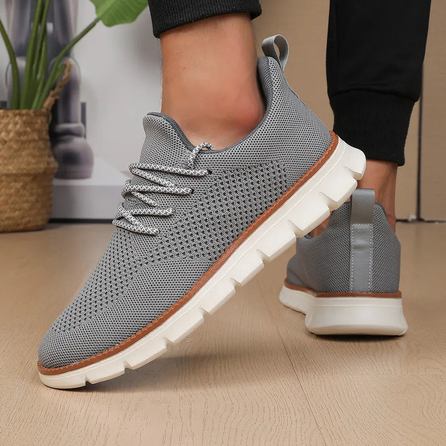 Men's grey and black low-heel casual sneakers with woven mesh fabric uppers and round toe.
