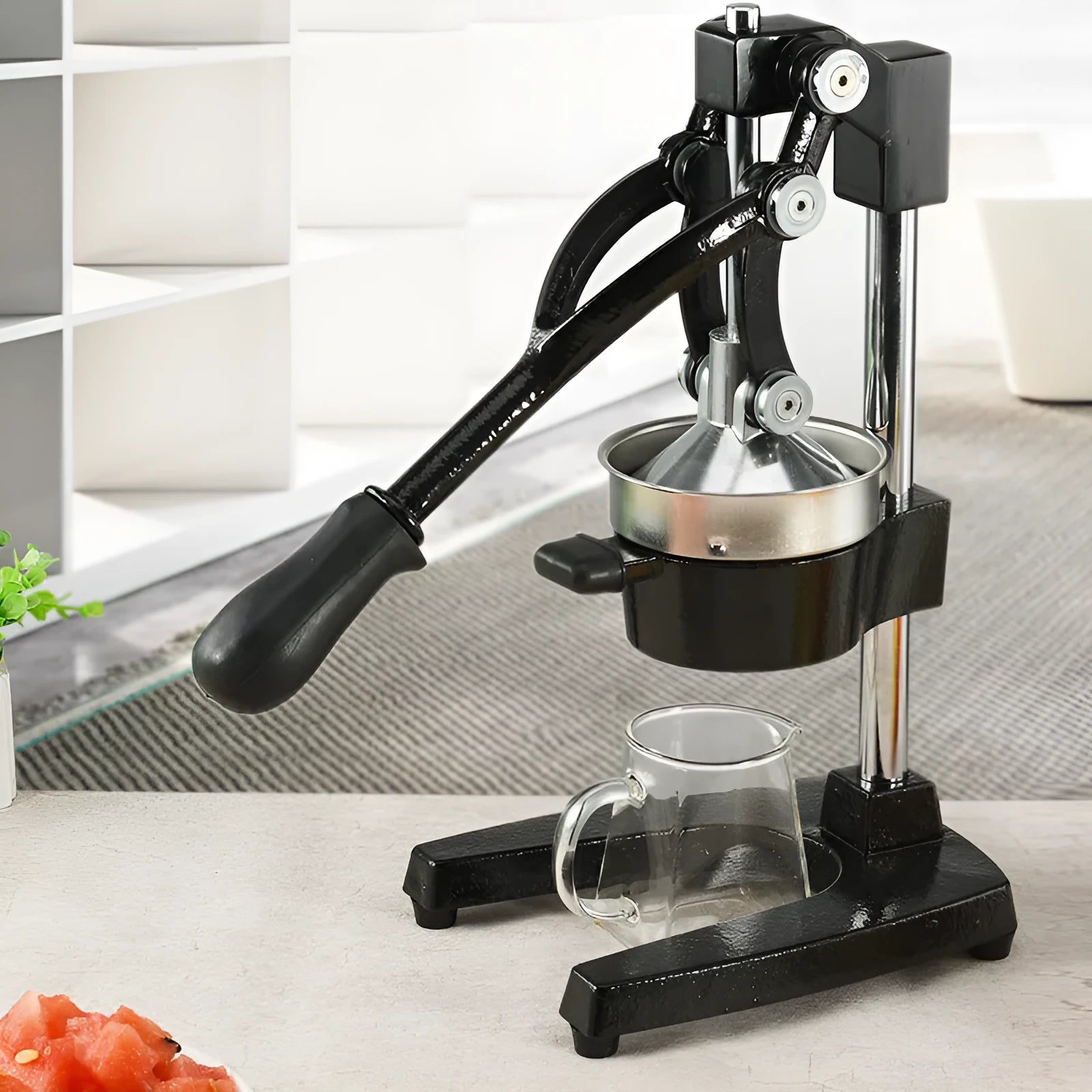 Black and white manual cast iron citrus juicer with stainless steel funnel, 40cm tall.