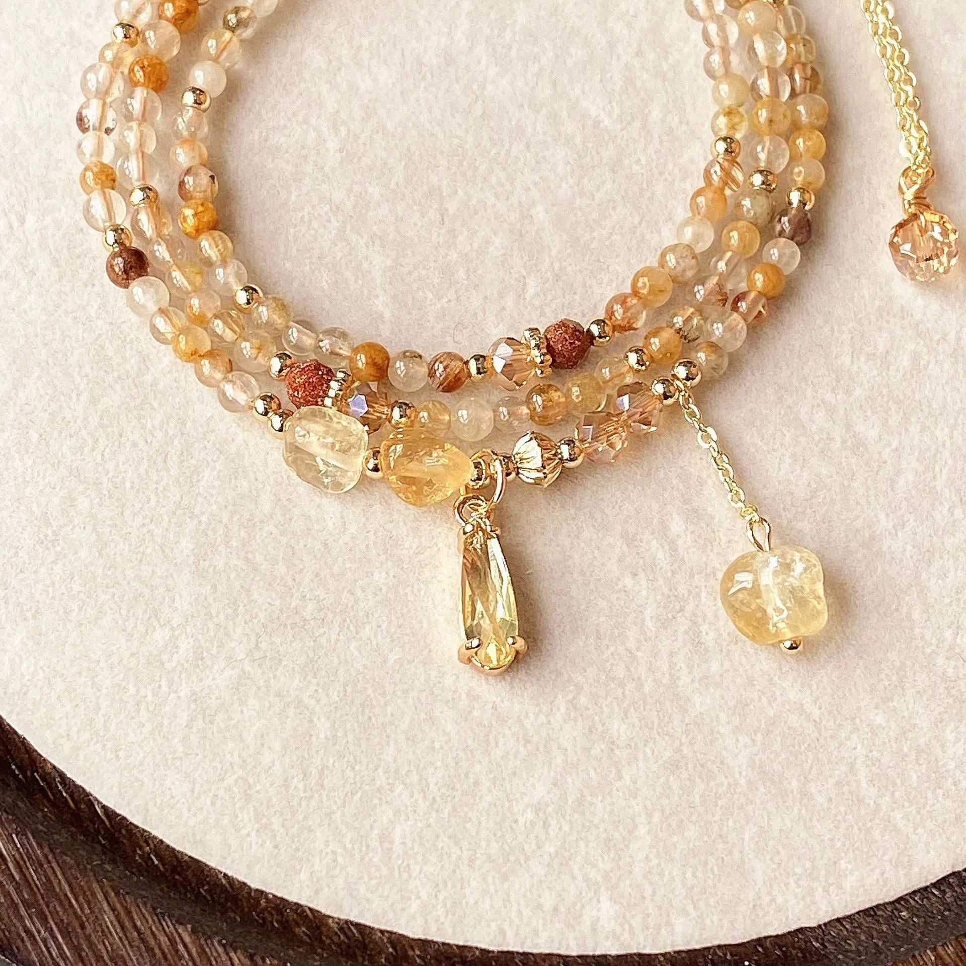 Gold tone women's bracelet with natural caramel coloured citrine crystal and Saturn decorative element