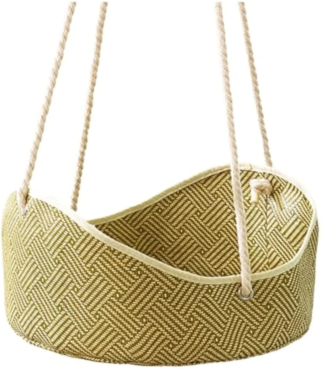 Green rattan cat hammock with metal hooks hanging on a white fence, a cat lounging inside.