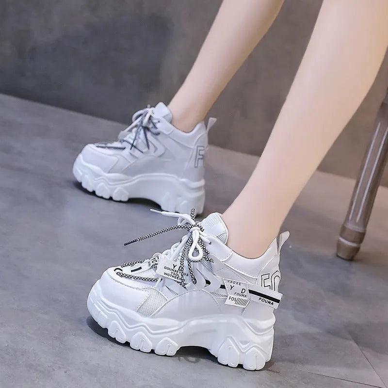 Women's white and black breathable mesh platform sports shoes with cross-strap and rubber sole.