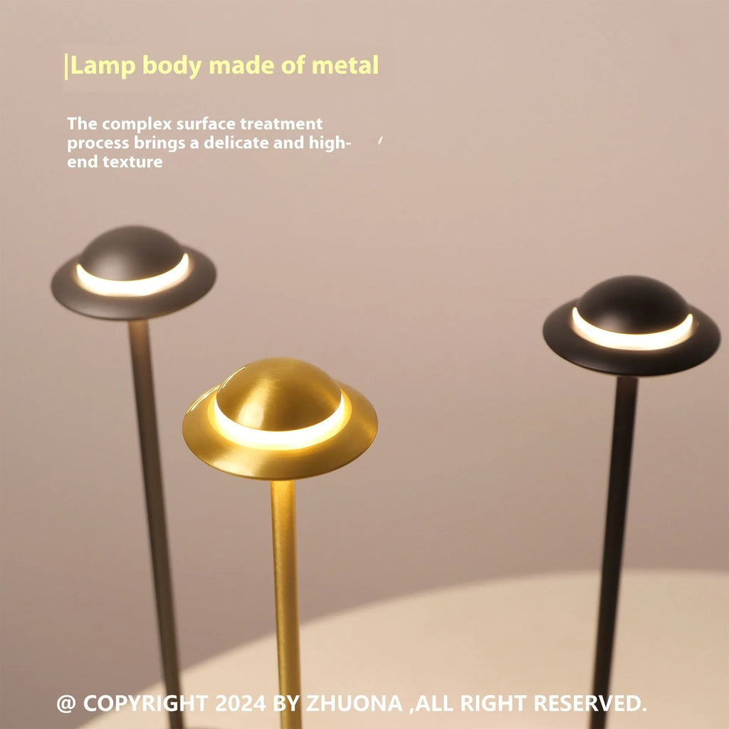 Metallic gold UFO-shaped rechargeable table lamp with touch-sensitive dimming controls.