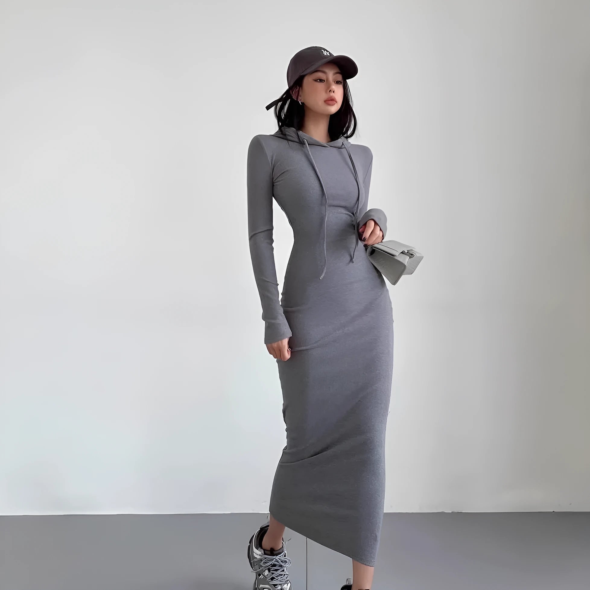 A light grey women's hooded sheath dress with long sleeves and a high waist on a model.
