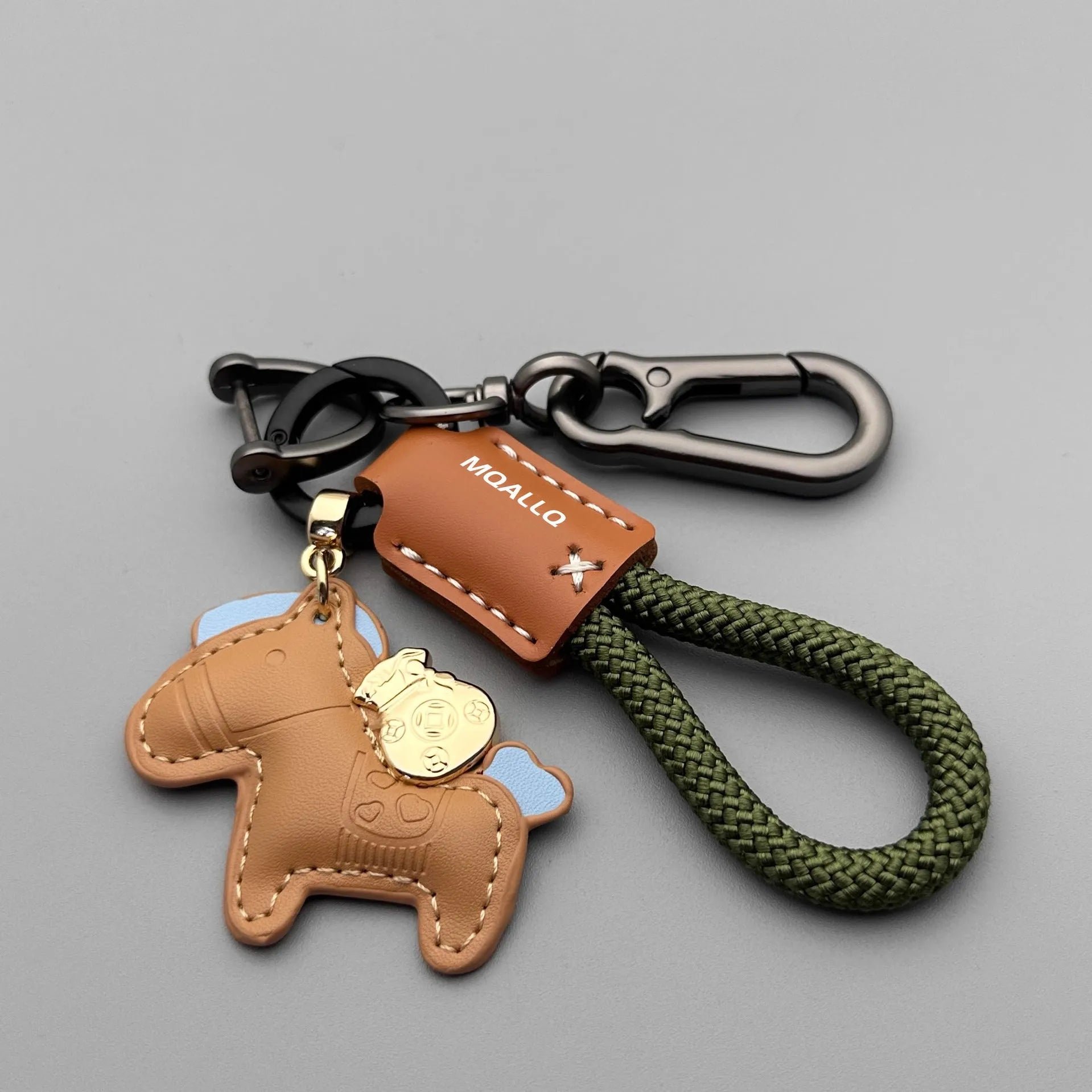 Handmade brown cowhide leather keychain with a zinc alloy pony belt buckle on a green flanelle rope.