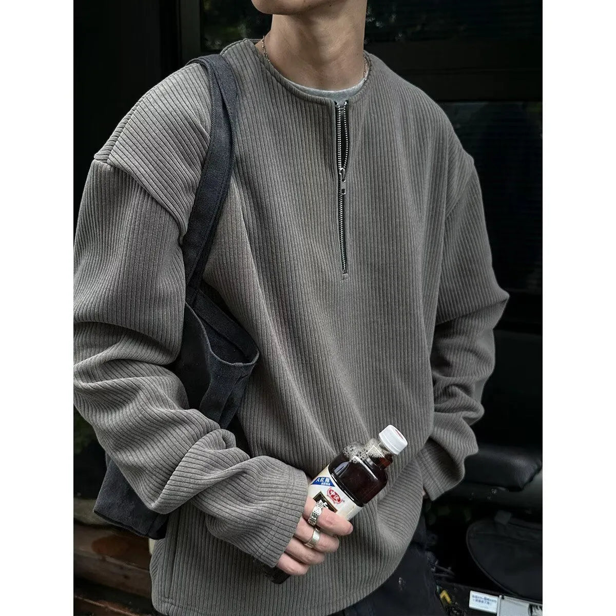 A grey women's loose-fitting long sleeve pullover top with a small letter pattern, shown on a hanger.