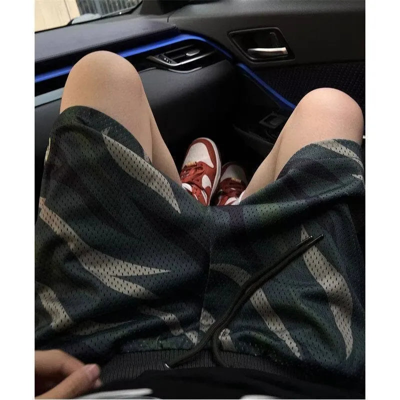 Men's straight-leg camouflage shorts in a cotton-blend fabric on a hanger.