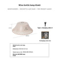 Beige and grey wine bottle-shaped camping lantern showing its compact size and light gear switch.