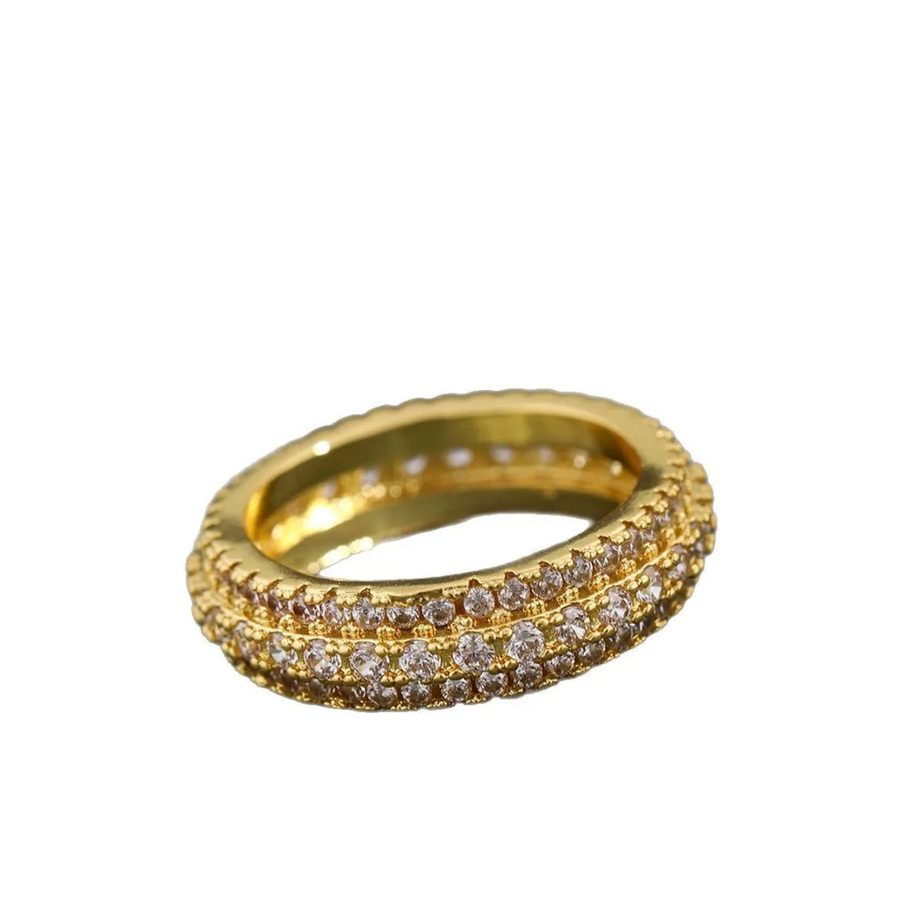 Geometric copper ring with a triangular zircon stone inlay, shown on a finger.