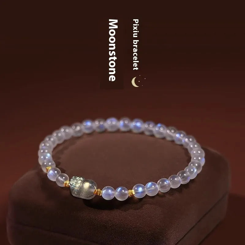 Close-up of a moonstone bracelet with a carved animal or zodiac design, showing grinding finish and blue light trend detail.