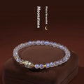 Close-up of a moonstone bracelet with a carved animal or zodiac design, showing grinding finish and blue light trend detail.
