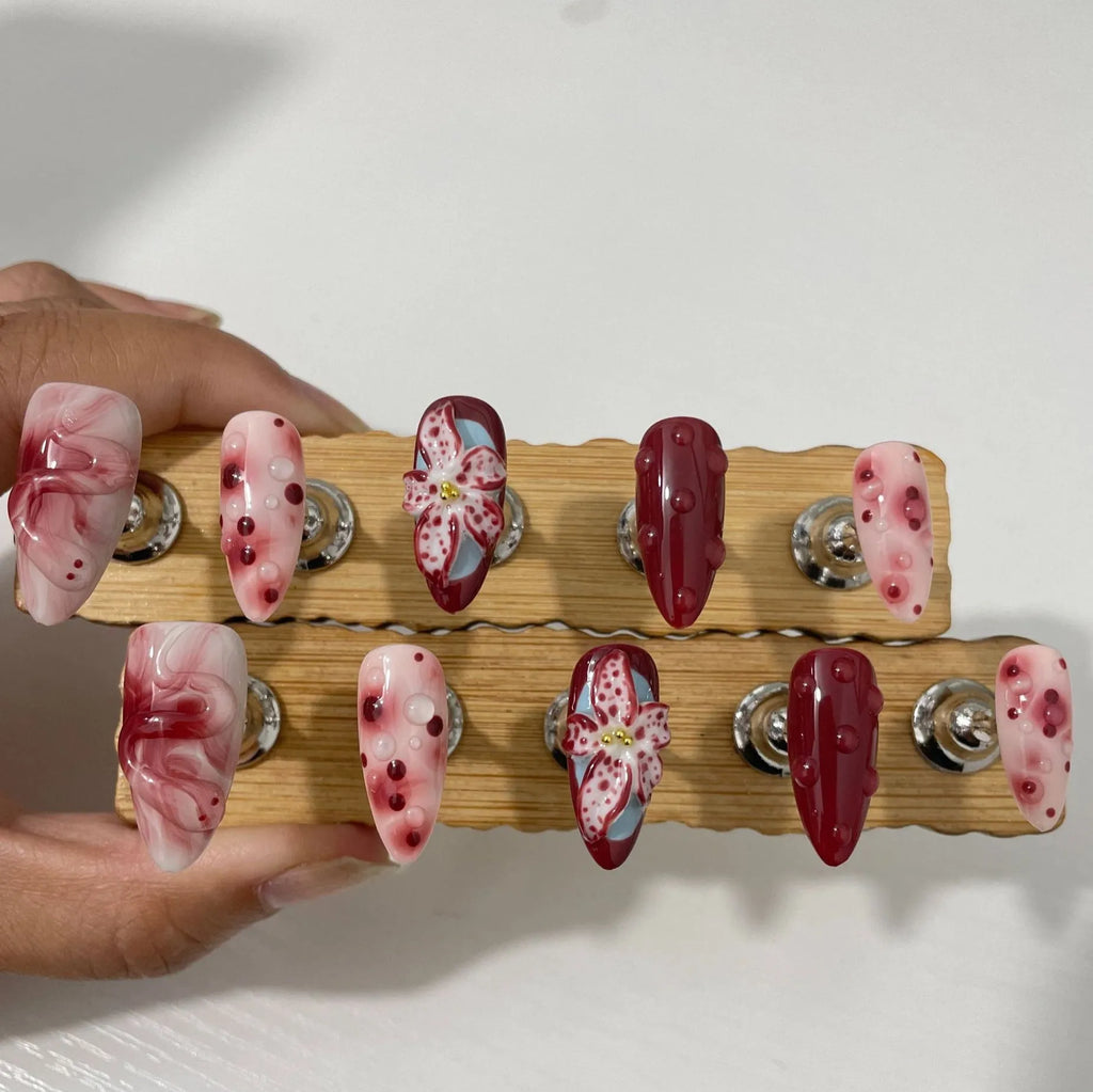 Hand-painted 3D floral artificial press-on nails in almond colour with cat's eye finish.