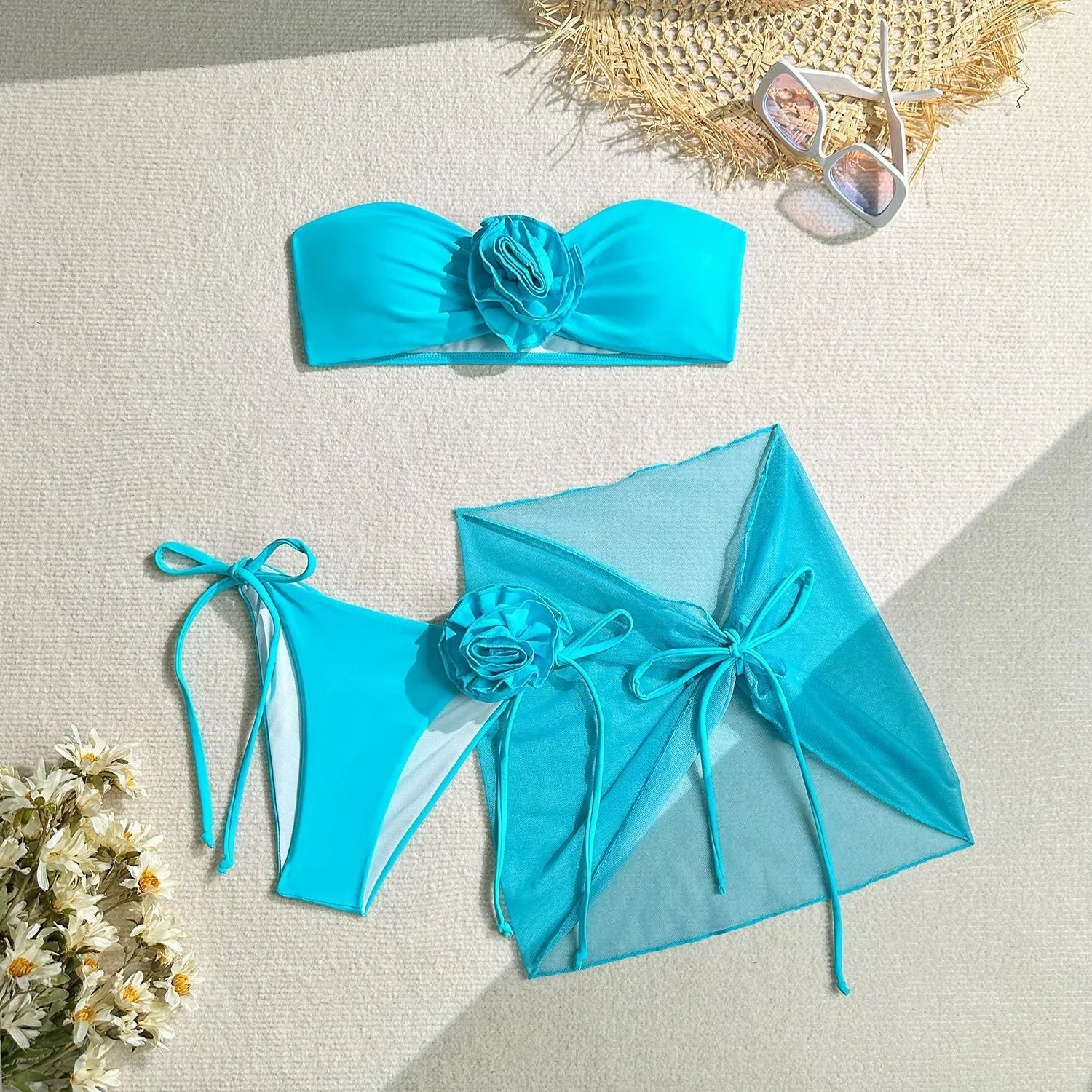 Women's blue tube top swimsuit with a large tied flower, matching pants and skirt.
