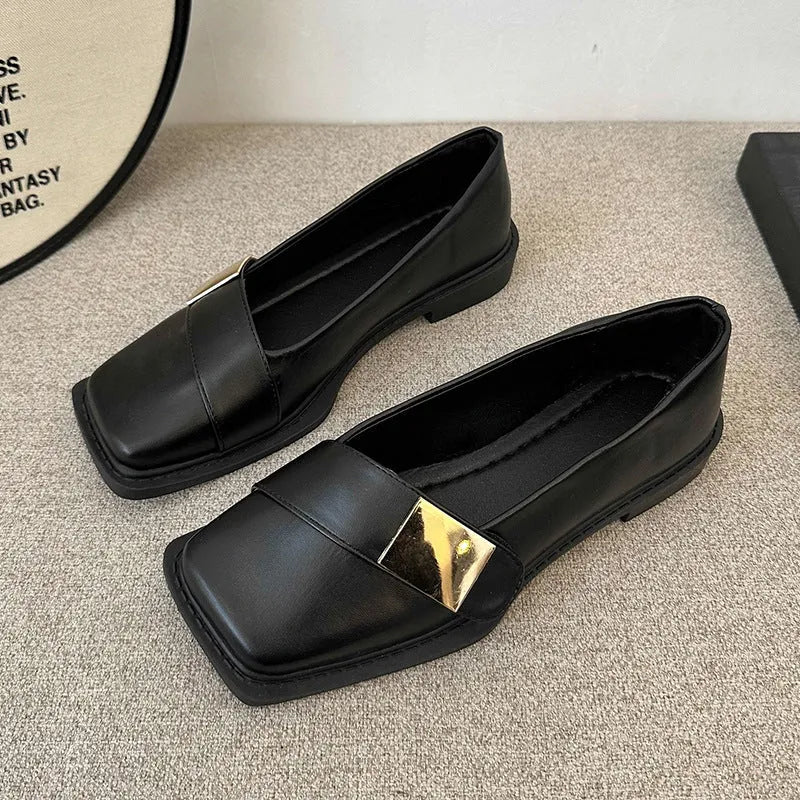 Women's beige square-toe flat shoes with a metal buckle and low rubber sole.