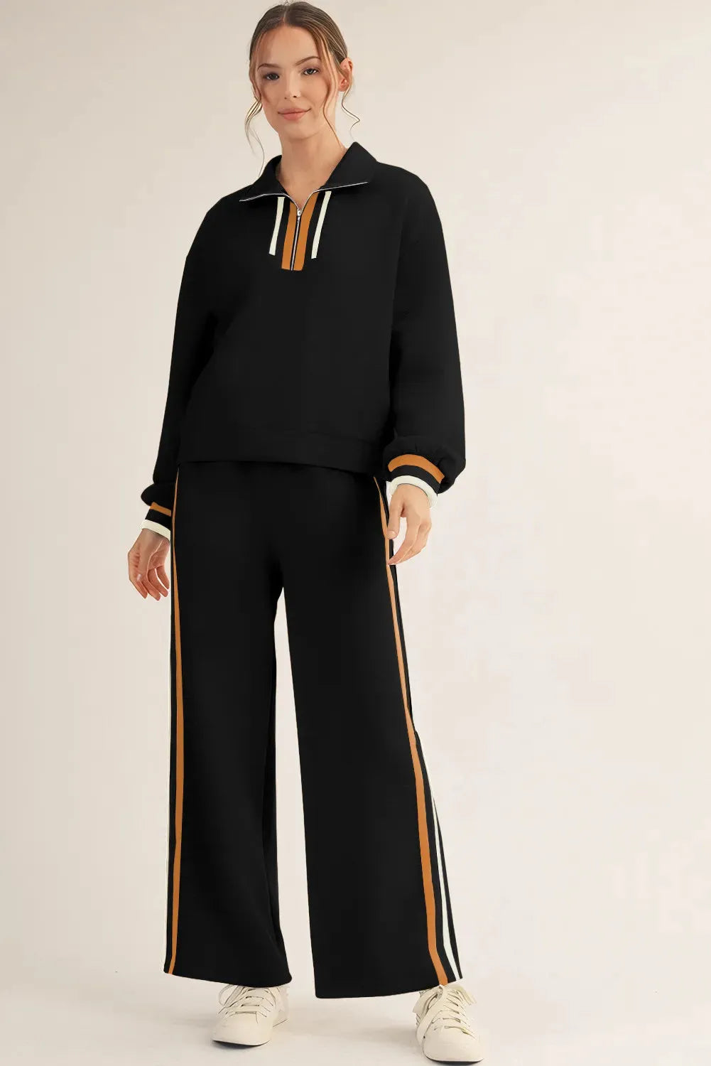 Black striped patchwork quarter zip pullover and loose pant set on a model, showing loose fit and striped detailing.