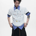 Man wearing a loose fit blue short sleeve shirt with a large cartoon graphic print on the front.