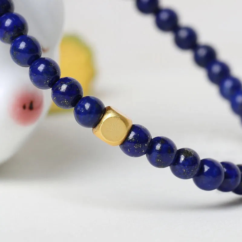 Close-up of a women's bracelet with a large 16mm geometric green gold stone crystal bead.
