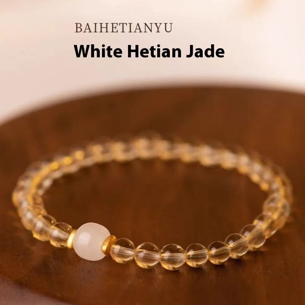 Handmade natural rutilated quartz bracelet with golden needles on wrist, showing 8mm beads.