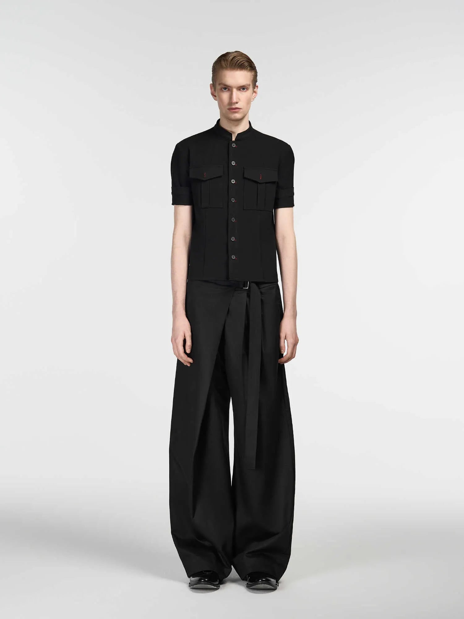 Black straight leg trousers with a single front pleat and an adjustable waistband on a hanger.