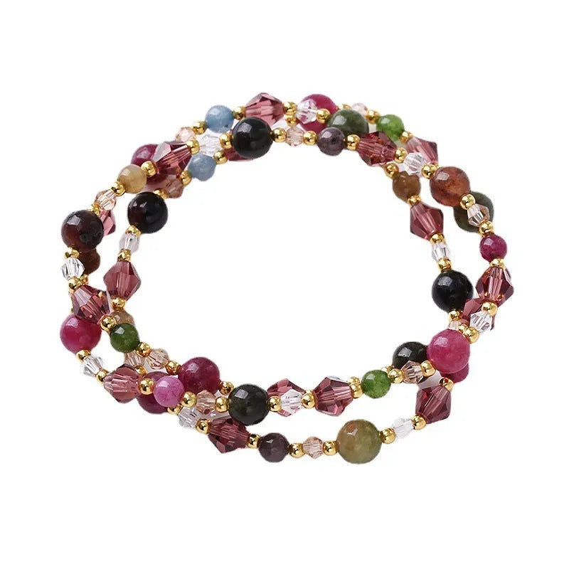 Women's three-ring crystal bracelet with tourmaline, strawberry quartz, and amethyst beads on adjustable rope.