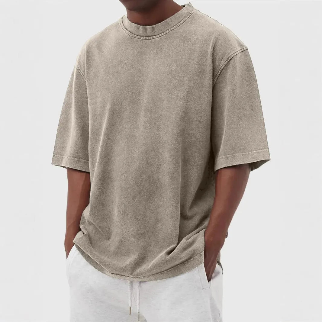 Man wearing a loose-fit, distressed army green pullover T-shirt with half sleeves.