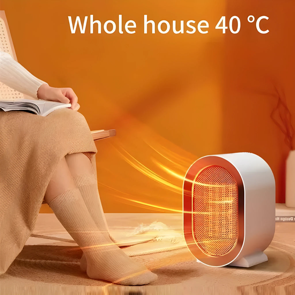 A compact black desktop electric fan heater with mechanical control dials, shown on a wooden desk.