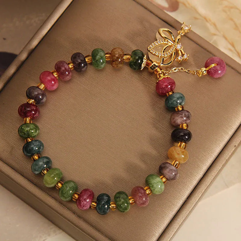 Colourful women's bracelet with butterfly charm and bead accents on alloy band