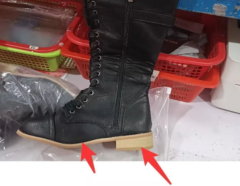 Women's black cross strap knight boots made from artificial PU, showing the strap detail and ankle height