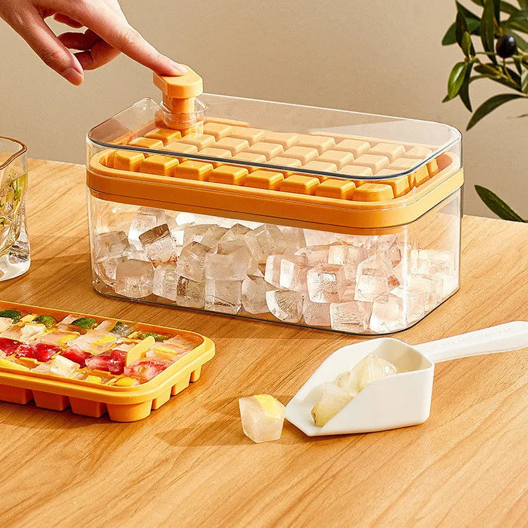 Green one-button press ice cube tray and storage box with lid on a kitchen counter