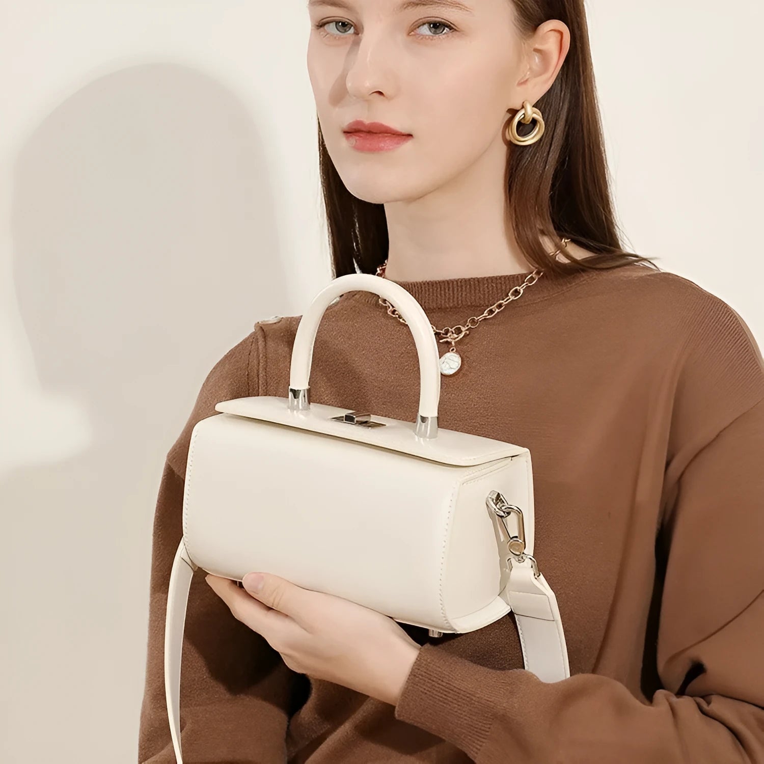 Brown leather women's crossbody bag with a box shape and clamshell opening, shown with interior phone and file pockets.