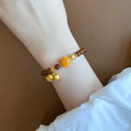 Caramel-coloured women's bracelet with electroplated beeswax finish and lily flower design.
