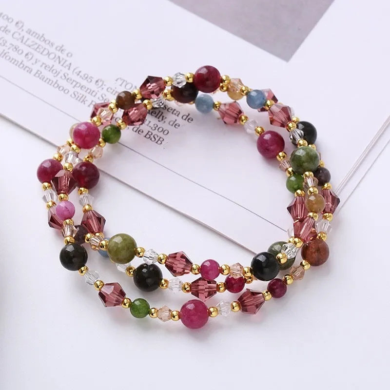 Women's three-ring crystal bracelet with tourmaline, strawberry quartz, and amethyst beads on adjustable rope.