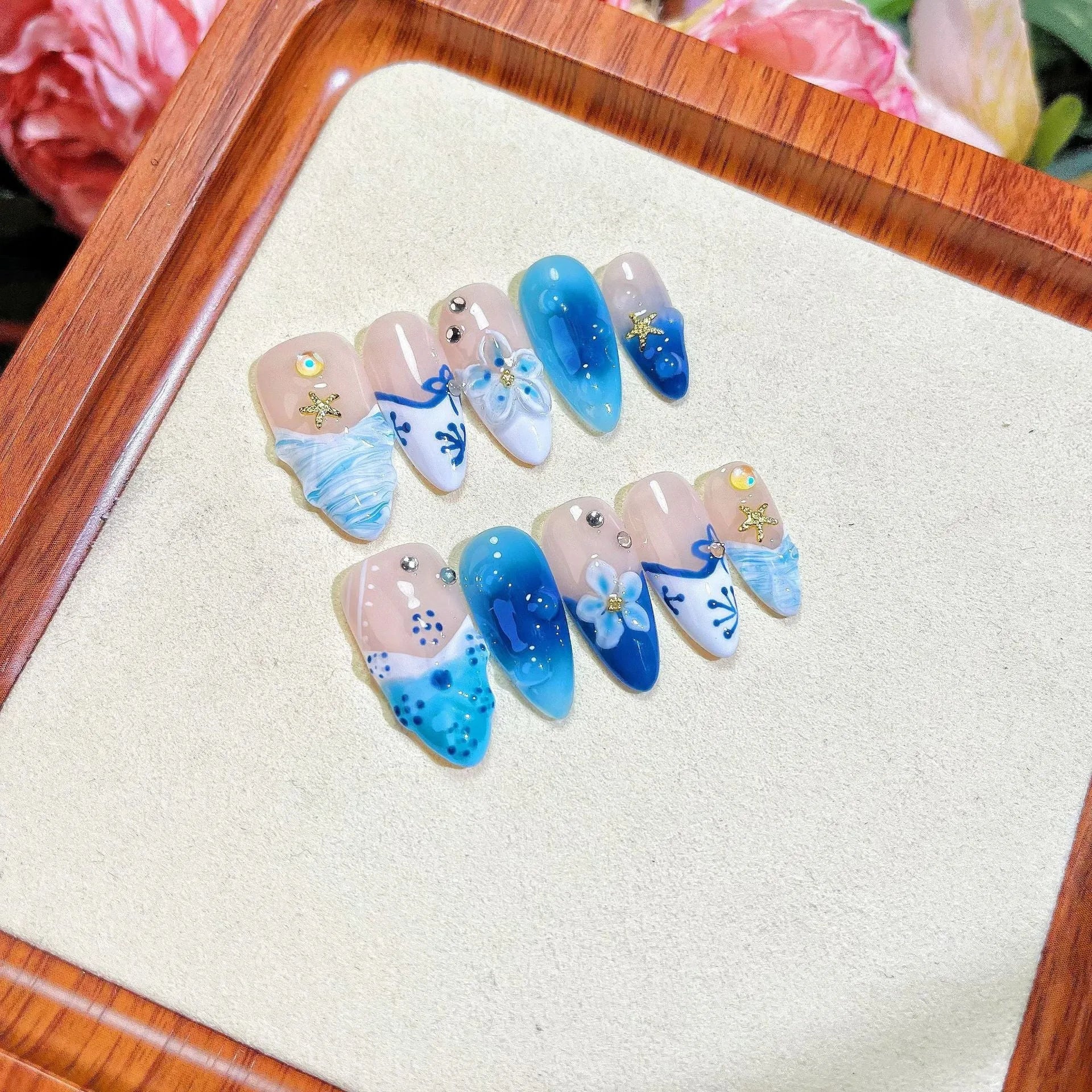 Set of blue hand-painted carved summer ice transparent plastic fake nails in XS, S, M, and L sizes.