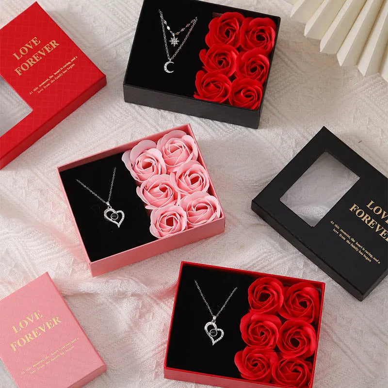 Red Korean-style gift box open to show six pink soap flowers, with a matching handbag beside it.