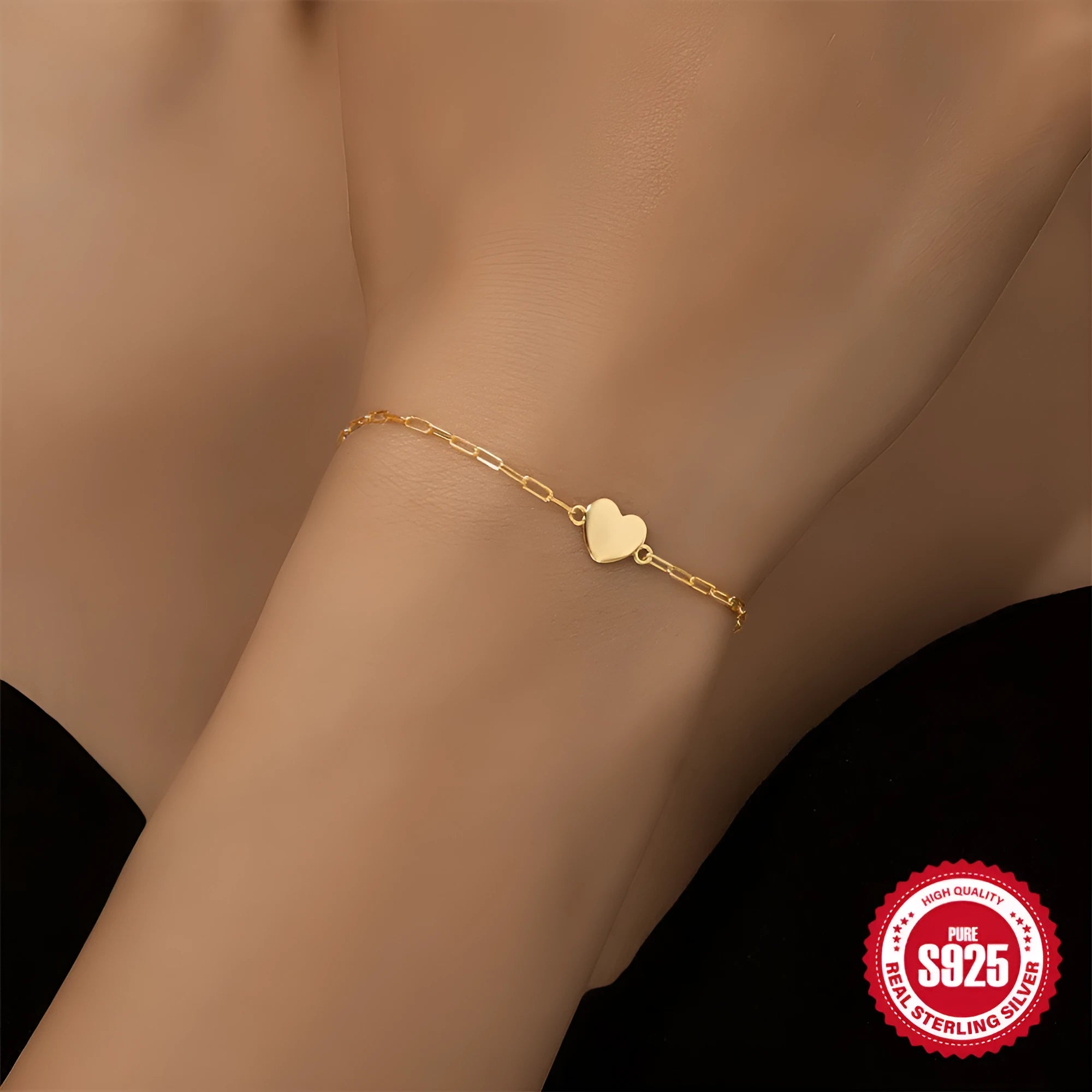 Close-up of a women's sterling silver bracelet with a glossy heart charm on an adjustable clip chain.