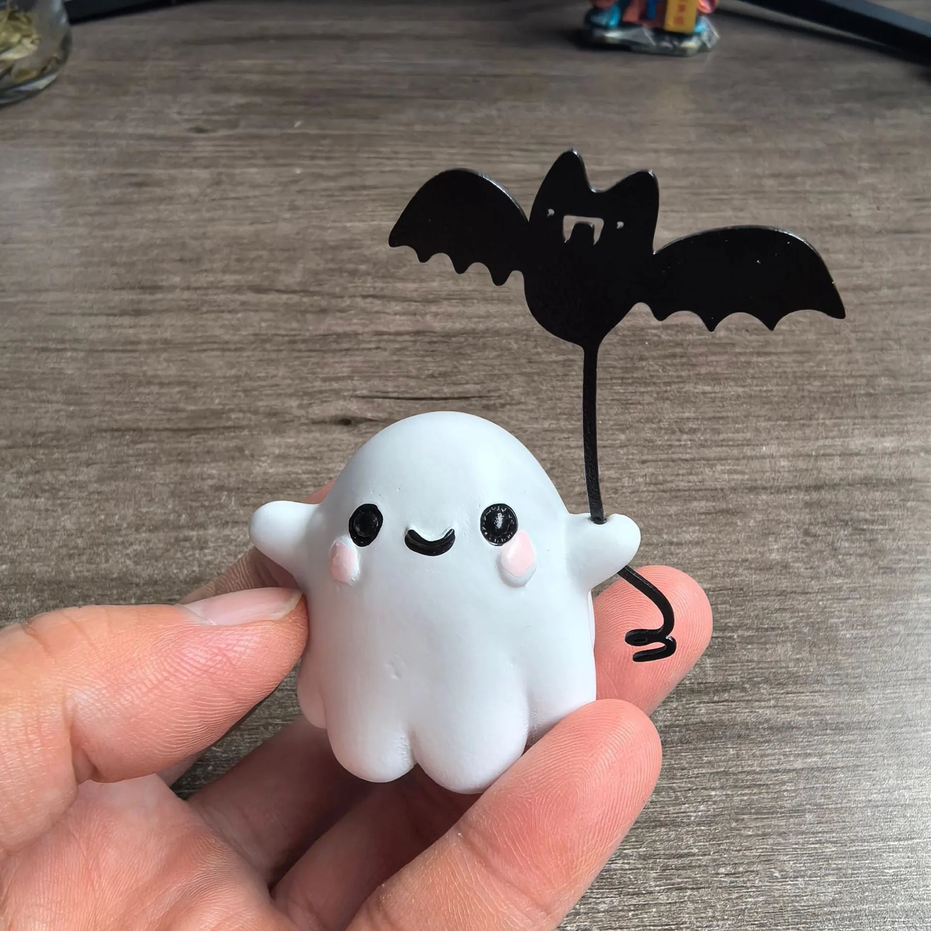 Miniature ghost walking dog statue holding a bat, a small resin Halloween ornament.