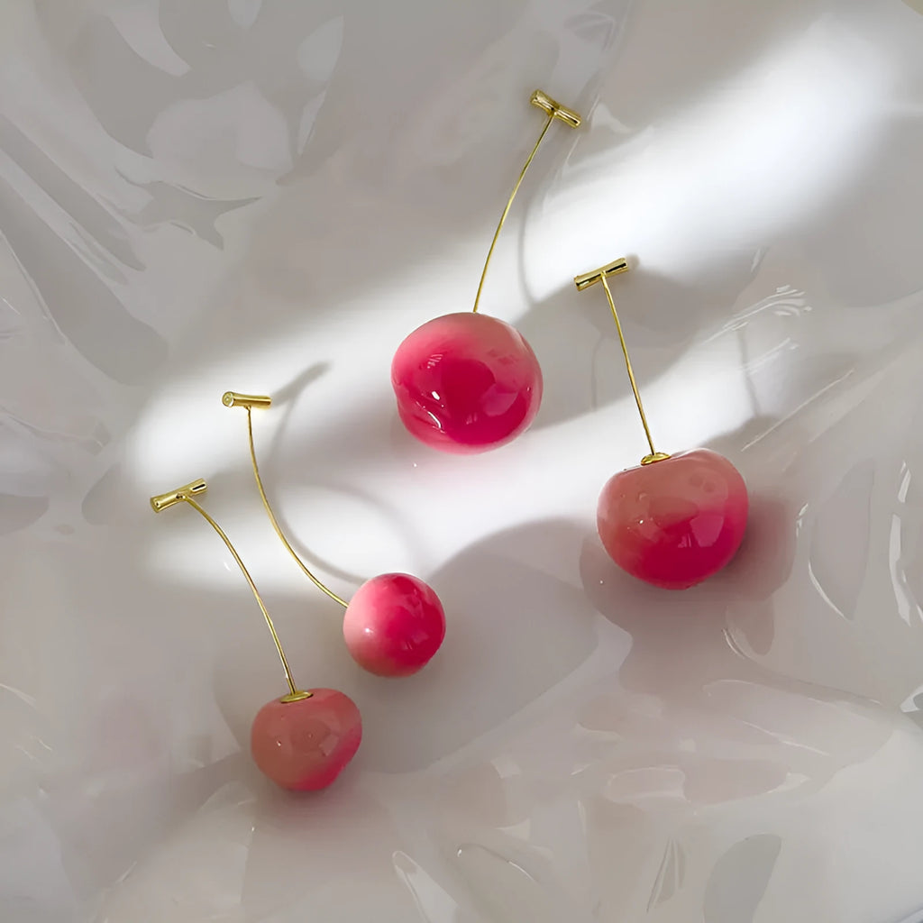 A pair of coloured acrylic peach fruit earrings on copper posts, shown in small and large size options.