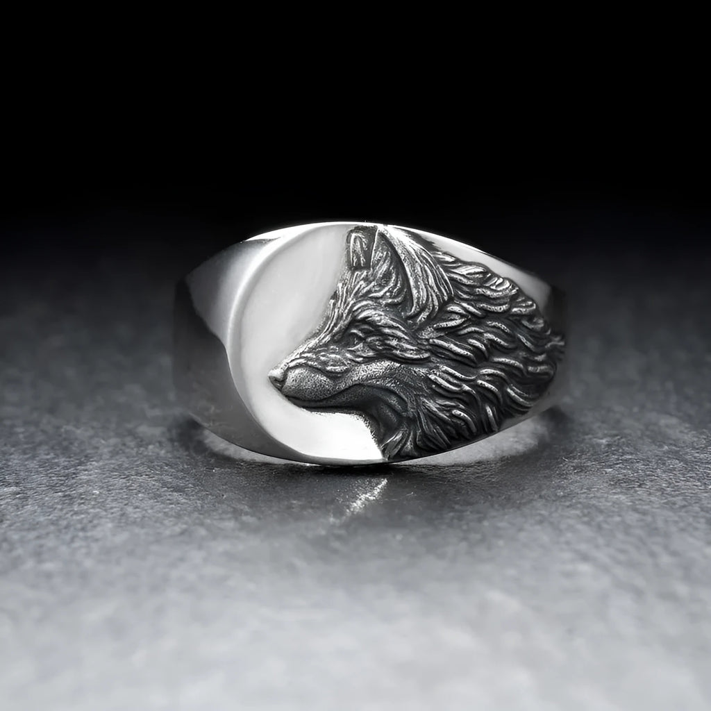 Silver men's ring with a geometric wolf design on a black background.