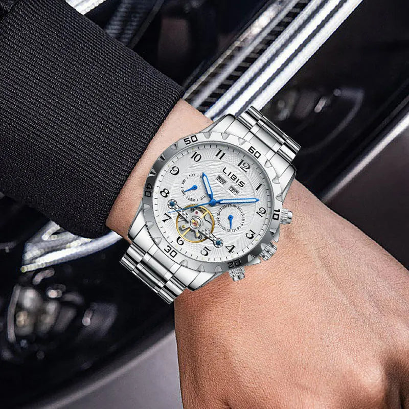 Men's silver automatic perpetual calendar watch with stainless steel strap on a wrist.