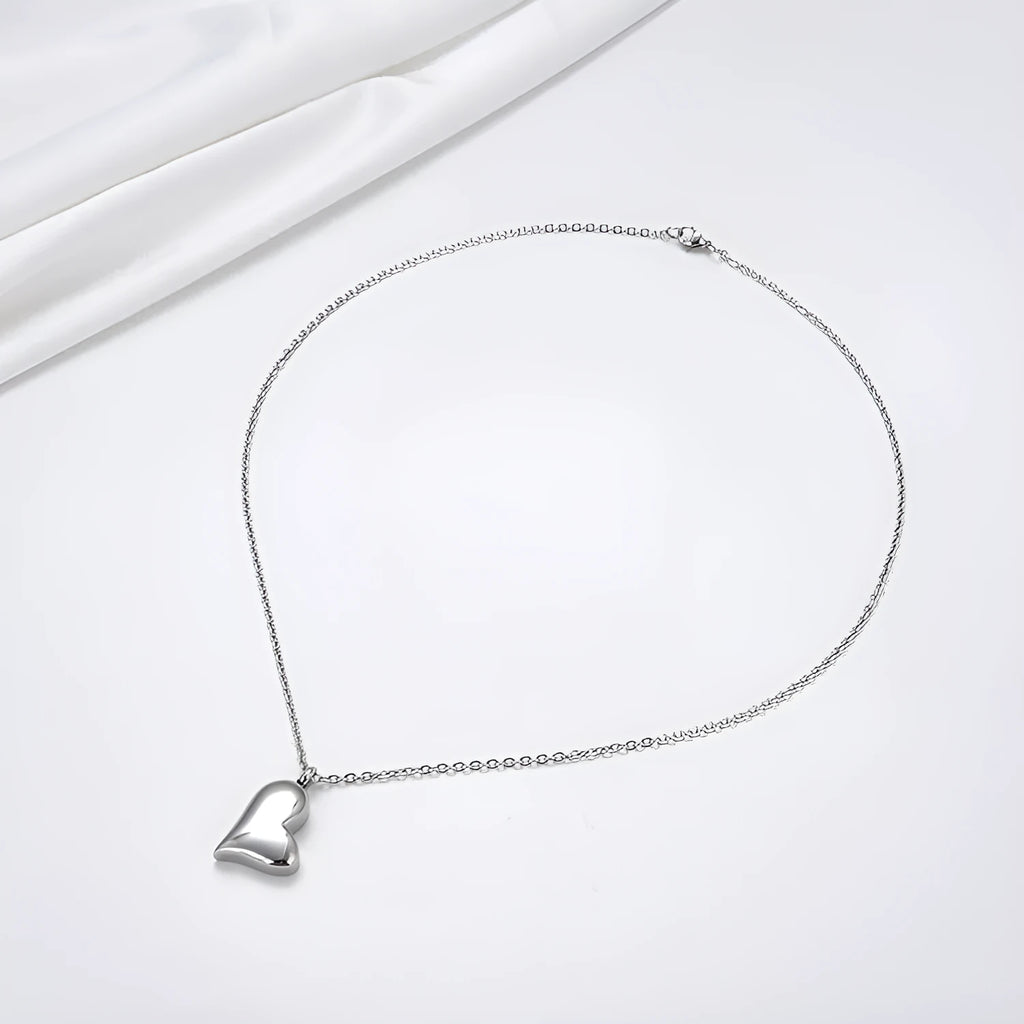 Silver curved peach heart stainless steel pendant necklace on display
