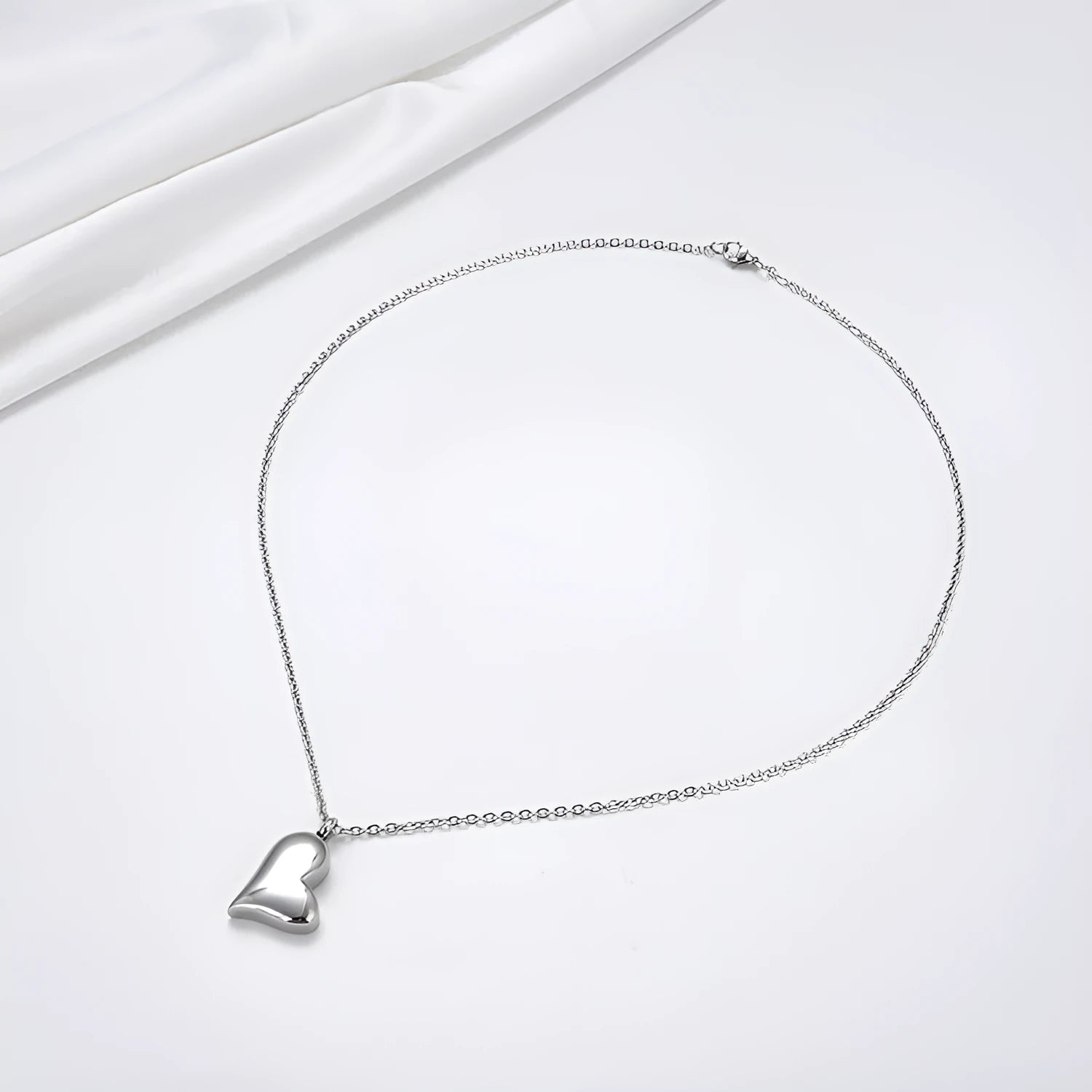 Silver curved peach heart stainless steel pendant necklace on display