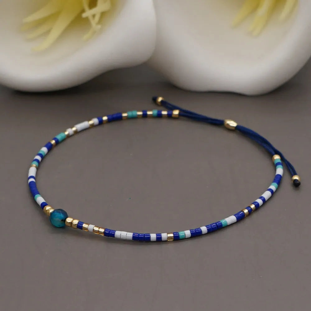 Close-up of a woman's handmade Bohemian bracelet with colourful geometric glass and glaze beads.