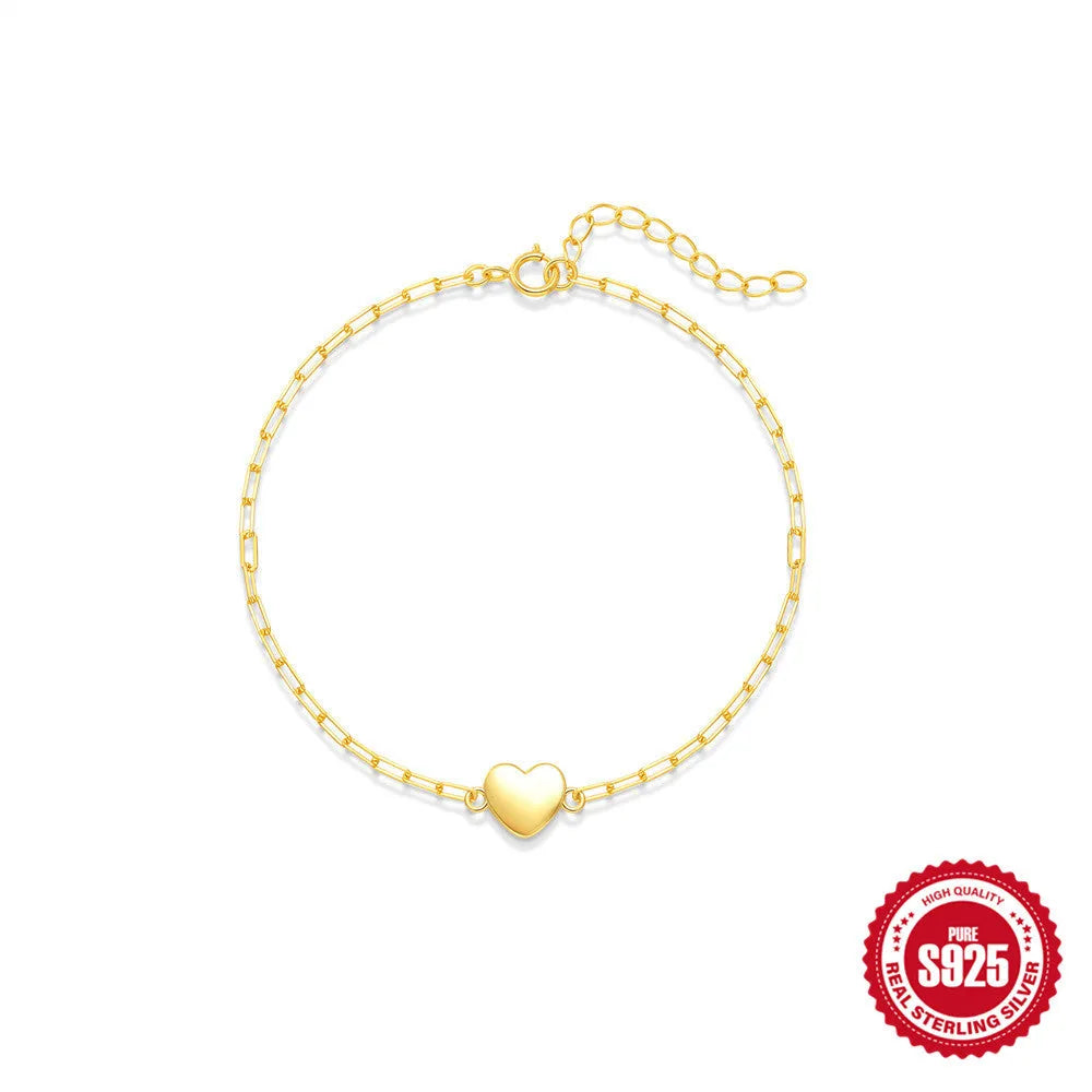 Close-up of a women's sterling silver bracelet with a glossy heart charm on an adjustable clip chain.