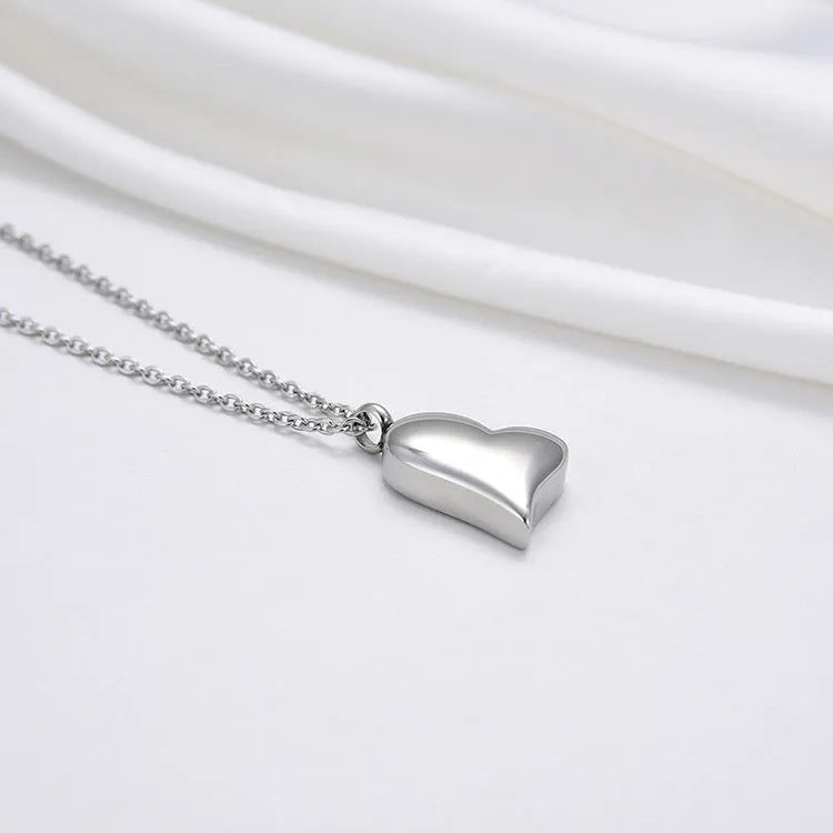 Silver curved peach heart stainless steel pendant necklace on display