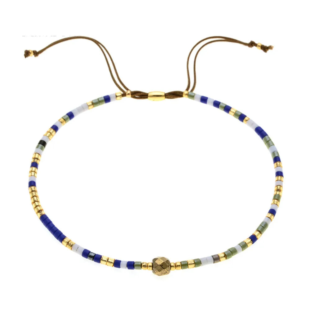 Close-up of a woman's handmade Bohemian bracelet with colourful geometric glass and glaze beads.