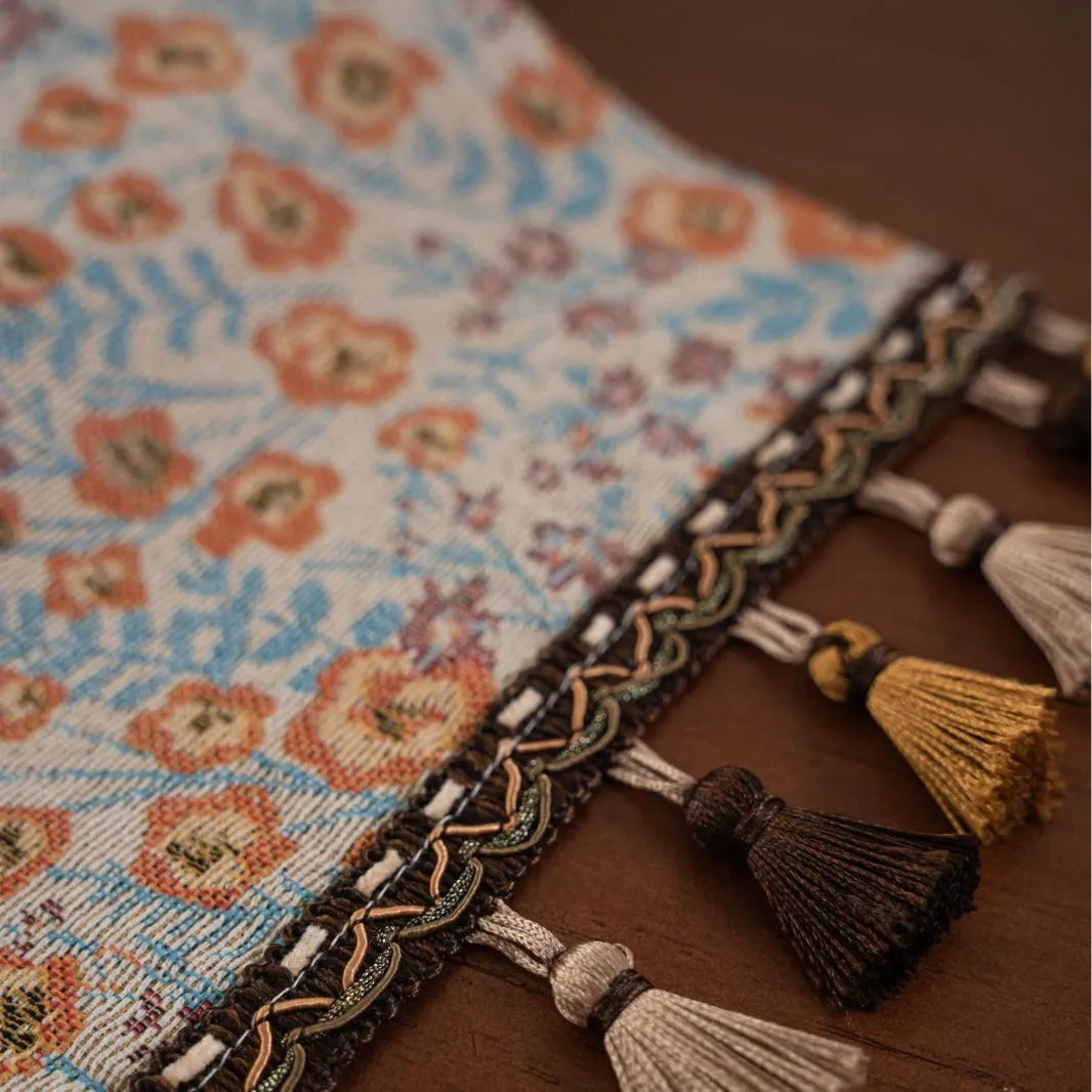 American-style beige jacquard table runner with long tassels and floral pattern on a dining table.