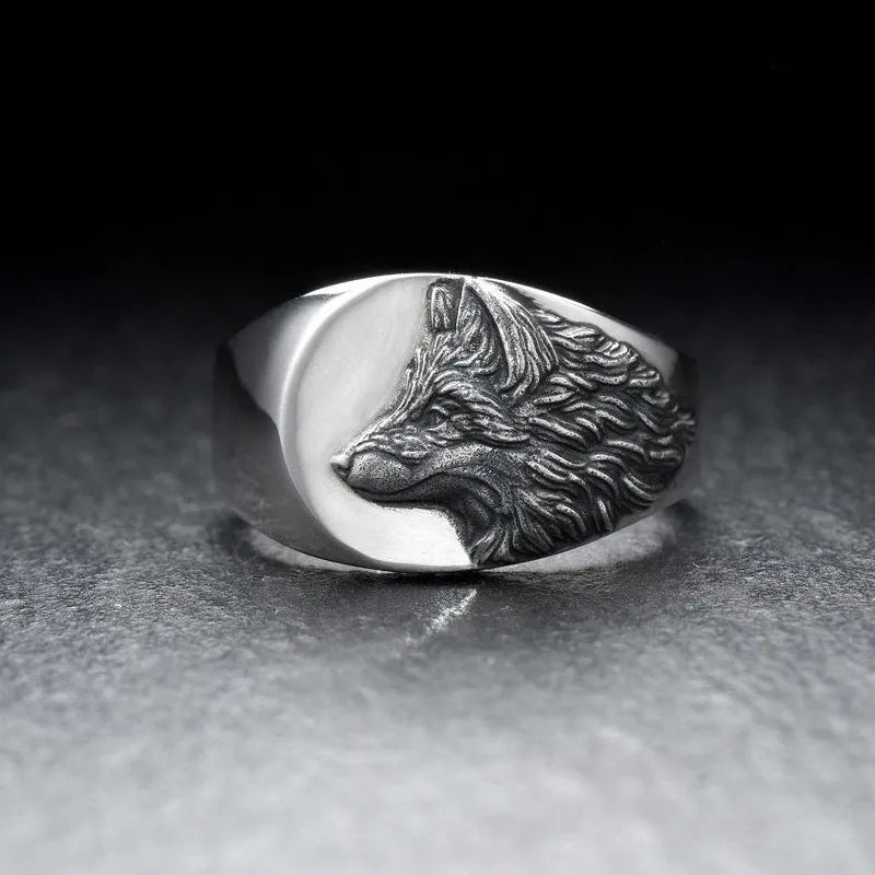 Silver men's ring with a geometric wolf design on a black background.