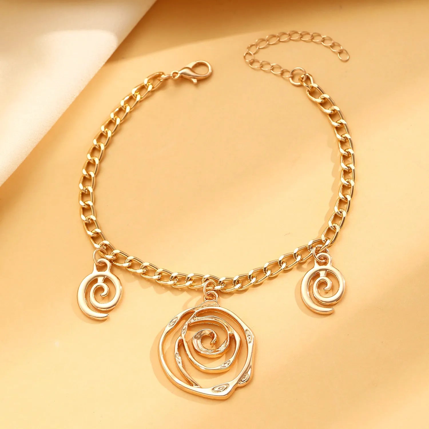 Spiral donut jewellery set showing necklace, bracelet, and ear hooks in gold or silver tone alloy