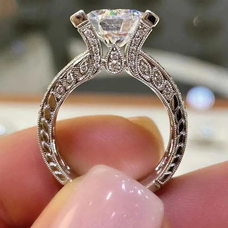 Geometric silver-toned women's ring with a round design element on a hand.