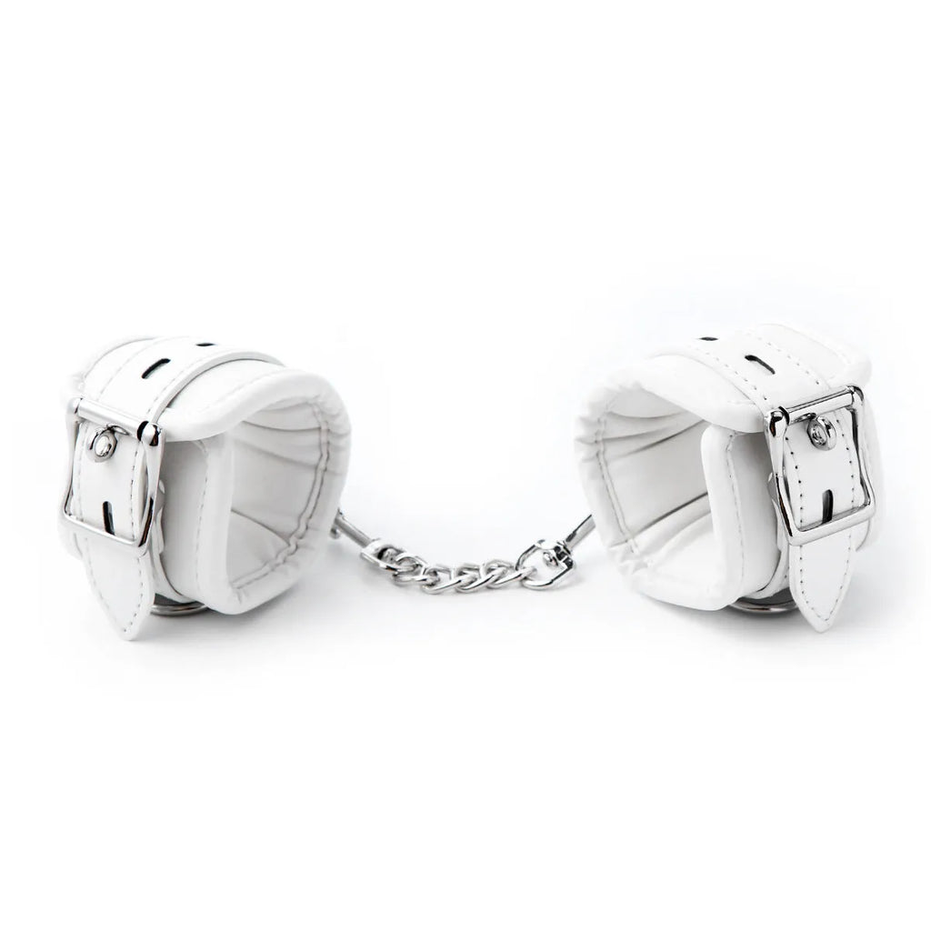 White PU sponge bondage set showing soft handcuffs, ankle cuffs, and a neck scarf laid out.