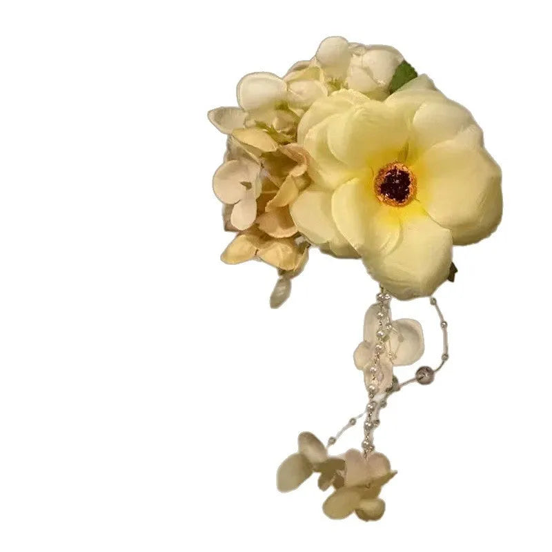 Yellow flower tassel side clip hair accessory for women on a purple background.